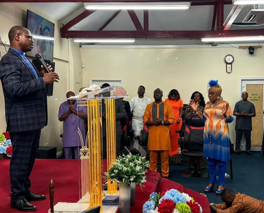 Pastor leading prayer with members of the congregation